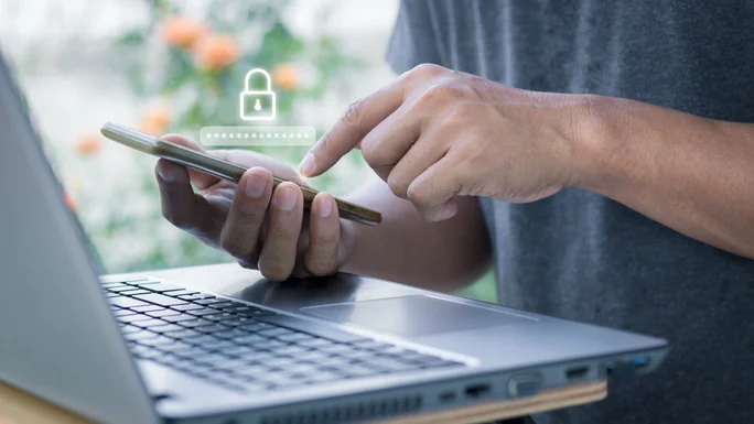 Asian businessman using the smart mobile phone to access on phone with laptop for validate password for biometric two steps authentication to unlock security, Business Technology security Concept