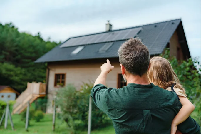 Happy couple of children dreaming of a house with solar panels. Solar energy panel concept. Alternative energy.