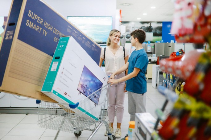 Mom and son buying large TV sets in the shopping mall, taking them out to the parking lot.